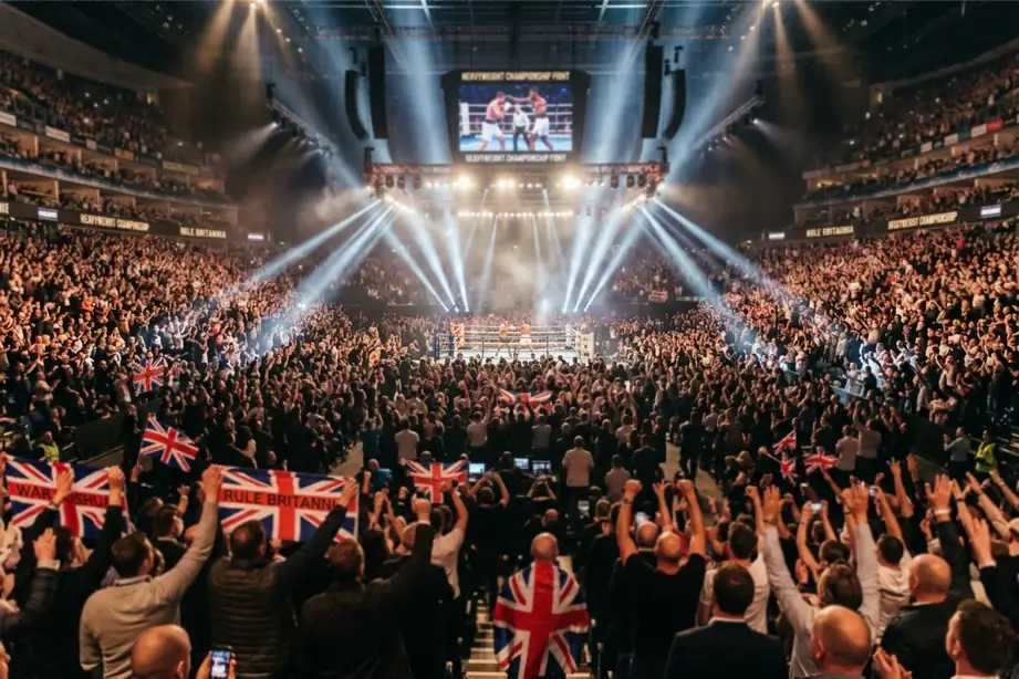 Packed British boxing arena crowd cheering during a heavyweight championship bout